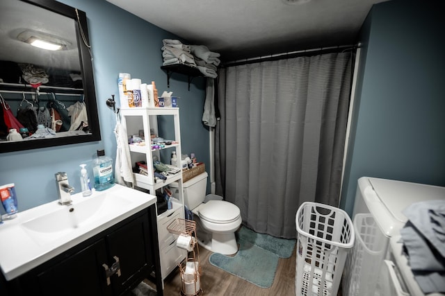 bathroom featuring toilet, vanity, a shower with shower curtain, and wood finished floors