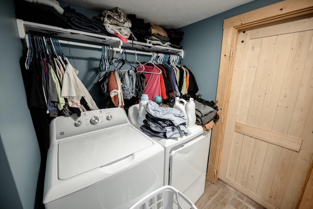 washroom with laundry area, light wood-type flooring, and washer and clothes dryer