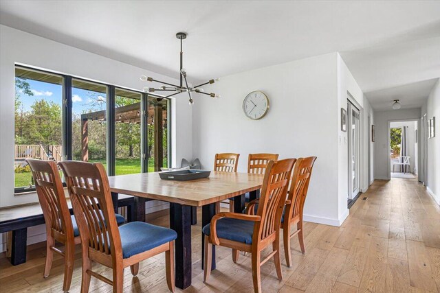 5407 Browntown Rd, Sawyer, MI 49125 - dining space featuring a chandelier, light wood-type flooring, and baseboards