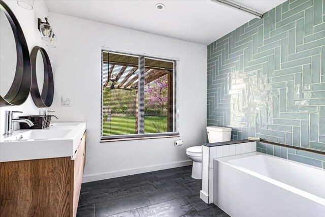 5407 Browntown Rd, Sawyer, MI 49125 - bathroom with toilet, a garden tub, baseboards, and double vanity