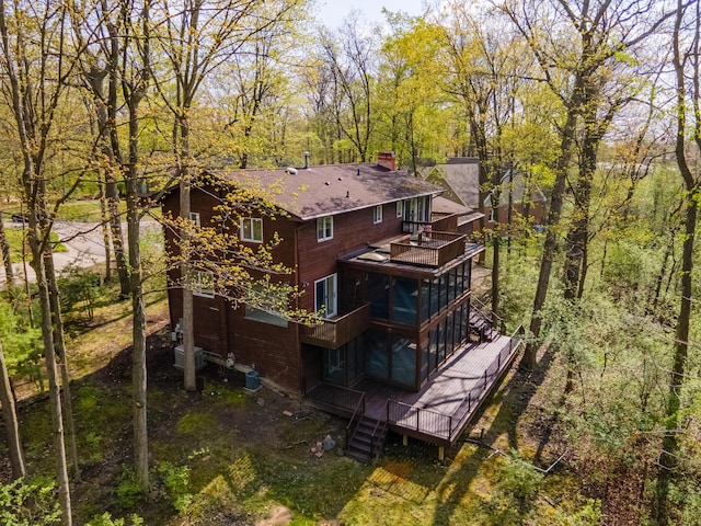 3949 Waldenwood Dr, Ann Arbor, MI 48105 - back of property featuring a sunroom, a chimney, a balcony, a shingled roof, and a deck