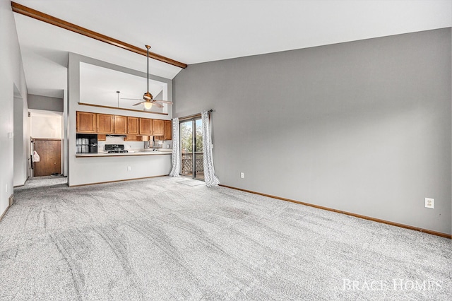 unfurnished living room with a ceiling fan, baseboards, light colored carpet, beamed ceiling, and high vaulted ceiling