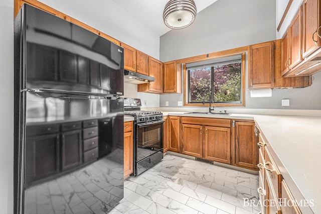 kitchen featuring black appliances, under cabinet range hood, a sink, light marble finish flooring, and light countertops
