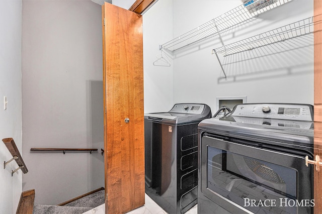 clothes washing area with washing machine and dryer and baseboards