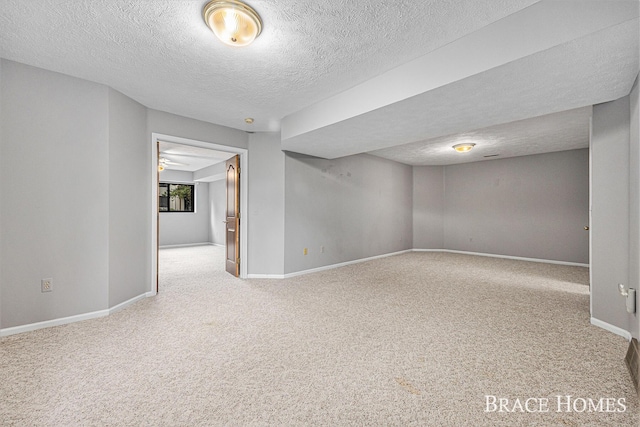 unfurnished room with carpet floors, a textured ceiling, and baseboards
