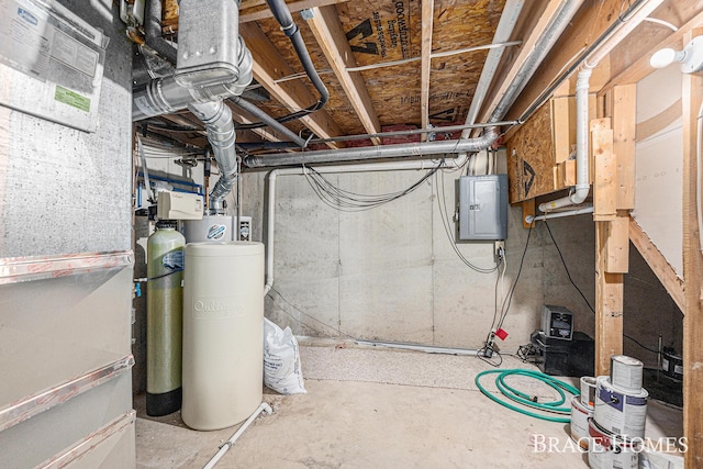 unfinished basement with electric panel and a water softener