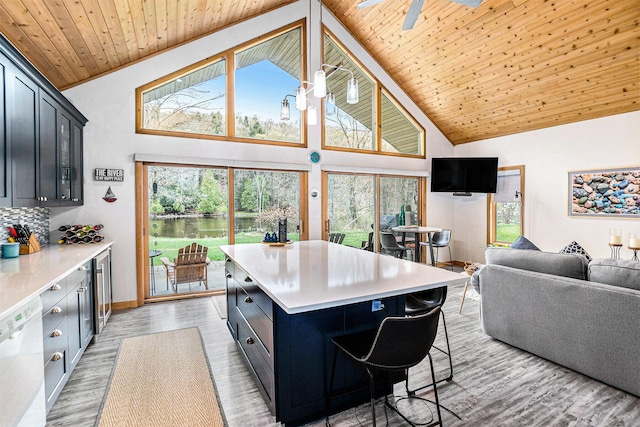17389 Rapids Dr, Hersey, MI 49639 - kitchen featuring white dishwasher, light countertops, high vaulted ceiling, light wood-style flooring, and healthy amount of natural light