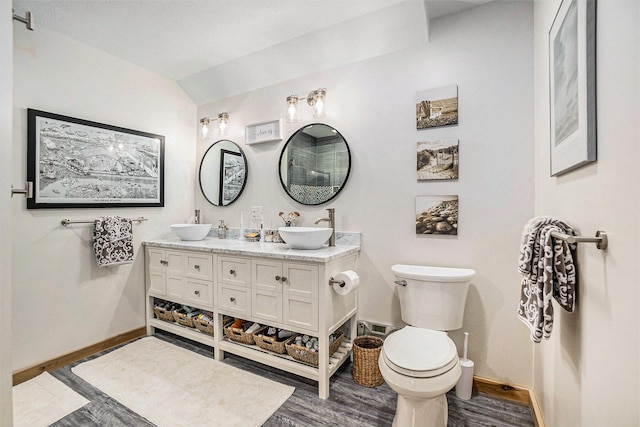 17389 Rapids Dr, Hersey, MI 49639 - bathroom with baseboards, toilet, wood finished floors, double vanity, and vaulted ceiling