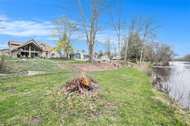 17389 Rapids Dr, Hersey, MI 49639 - view of green lawn with a fire pit and a water view