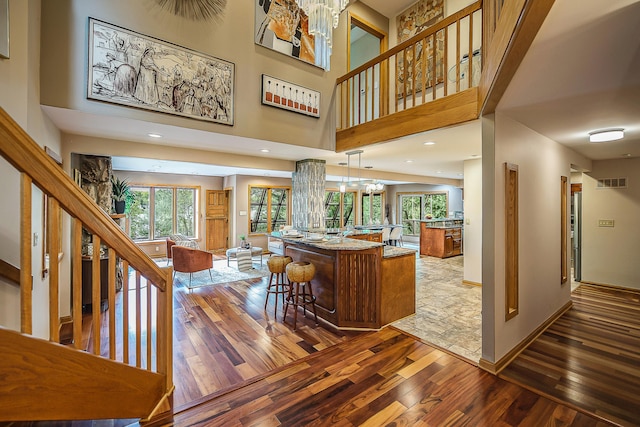 10985 E Pleasant Lake Rd, Manchester, MI 48158 - kitchen featuring open floor plan, wood-type flooring, a chandelier, healthy amount of natural light, and a high ceiling