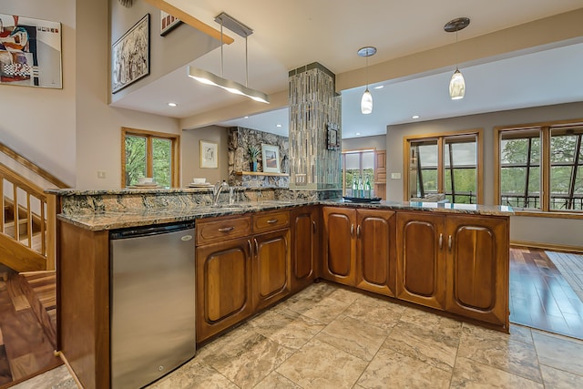 10985 E Pleasant Lake Rd, Manchester, MI 48158 - kitchen with healthy amount of natural light, brown cabinets, dark stone counters, and hanging light fixtures