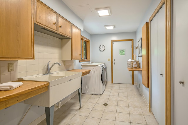 10985 E Pleasant Lake Rd, Manchester, MI 48158 - laundry room featuring washing machine and dryer, light tile patterned floors, cabinet space, and baseboards