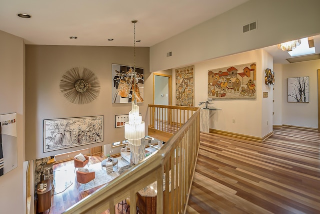 10985 E Pleasant Lake Rd, Manchester, MI 48158 - corridor with a chandelier, wood finished floors, an upstairs landing, vaulted ceiling, and baseboards