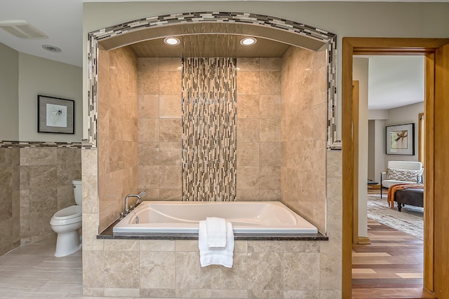 10985 E Pleasant Lake Rd, Manchester, MI 48158 - bathroom featuring tile walls, tiled bath, toilet, and recessed lighting
