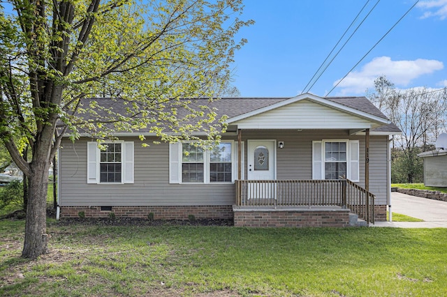 view of front of property with a front lawn, a shingled roof, covered porch, and crawl space