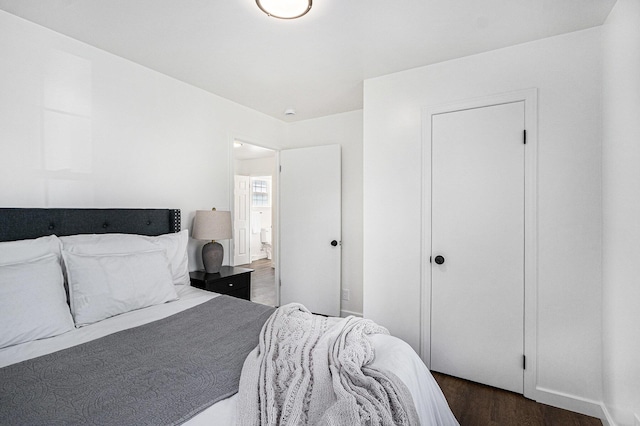bedroom with ensuite bath and wood finished floors