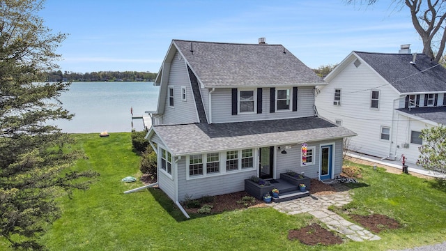 447 Paradise Ln, Horton, MI 49246 - view of front of house with roof with shingles, a front yard, and a water view