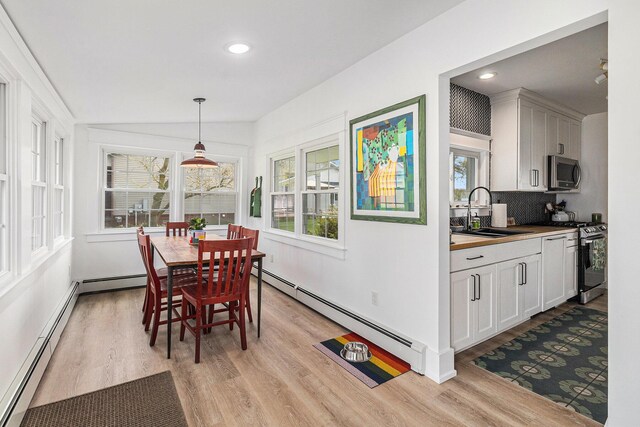 447 Paradise Ln, Horton, MI 49246 - dining area featuring baseboard heating, light wood-style floors, recessed lighting, baseboards, and vaulted ceiling