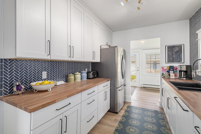 447 Paradise Ln, Horton, MI 49246 - kitchen featuring butcher block countertops, baseboard heating, and a sink