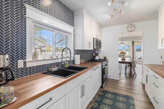 447 Paradise Ln, Horton, MI 49246 - kitchen with butcher block counters, appliances with stainless steel finishes, a sink, and tasteful backsplash