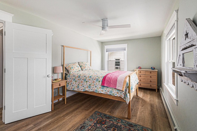 447 Paradise Ln, Horton, MI 49246 - bedroom featuring baseboard heating, dark wood-style floors, multiple windows, and a ceiling fan