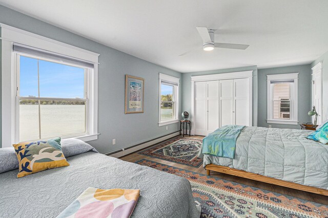 447 Paradise Ln, Horton, MI 49246 - bedroom featuring a baseboard radiator, ceiling fan, a closet, and wood finished floors