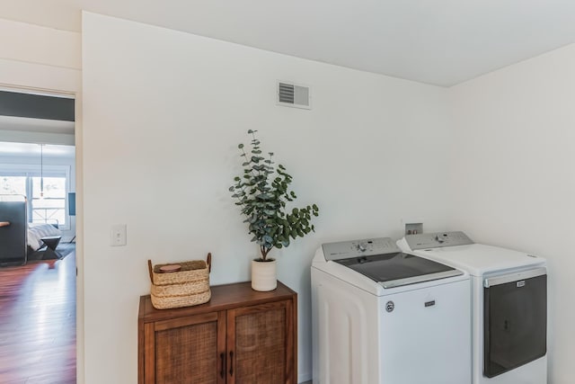 67592 95th Ave, Dowagiac, MI 49047 - washroom with washer and clothes dryer, cabinet space, and wood finished floors