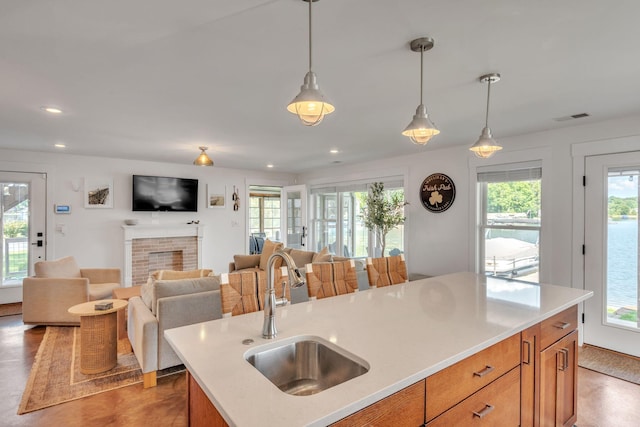 67592 95th Ave, Dowagiac, MI 49047 - kitchen featuring a sink, brown cabinetry, light countertops, hanging light fixtures, and recessed lighting