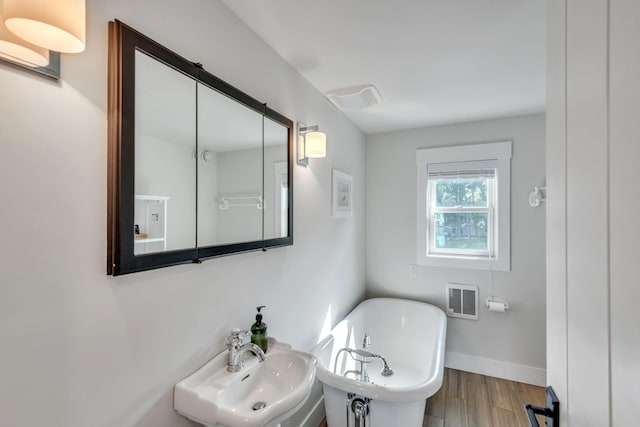 67592 95th Ave, Dowagiac, MI 49047 - full bathroom featuring a sink, a freestanding tub, wood finished floors, and baseboards