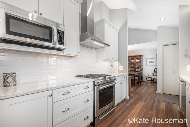 1334 Thornberry Ct W, Grand Rapids, MI 49546 - kitchen featuring white cabinets, wall chimney range hood, appliances with stainless steel finishes, tasteful backsplash, and dark wood-style floors
