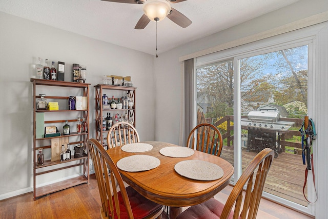 dining room with light wood-style floors, ceiling fan, and baseboards