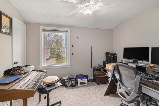 carpeted home office with ceiling fan, a textured ceiling, and lofted ceiling