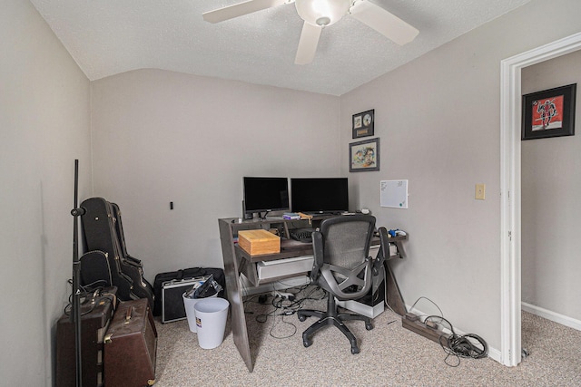 carpeted office space featuring a ceiling fan, lofted ceiling, and baseboards