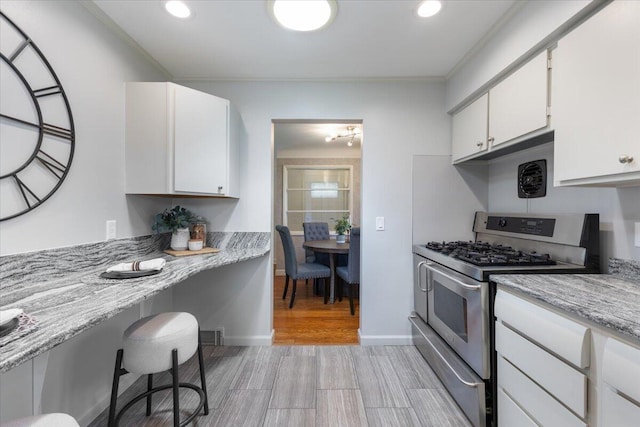 1610 Saunders Cres, Ann Arbor, MI 48103 - kitchen featuring stainless steel gas range, white cabinetry, light wood-style floors, ornamental molding, and recessed lighting
