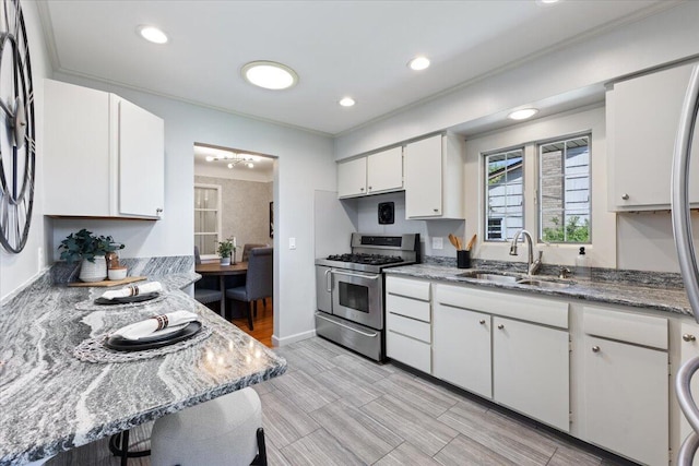 1610 Saunders Cres, Ann Arbor, MI 48103 - kitchen with white cabinets, range with two ovens, ornamental molding, and a sink