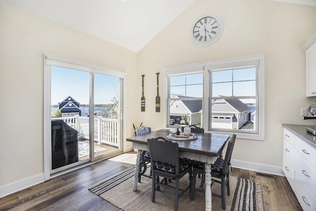 dining space with high vaulted ceiling, baseboards, dark wood-style floors, and visible vents
