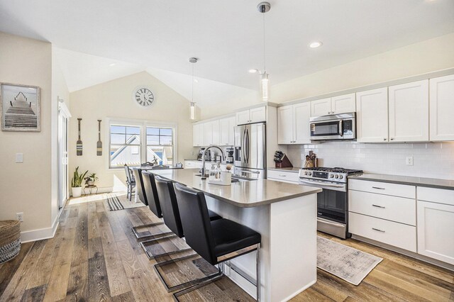 kitchen featuring white cabinets, backsplash, appliances with stainless steel finishes, and a sink
