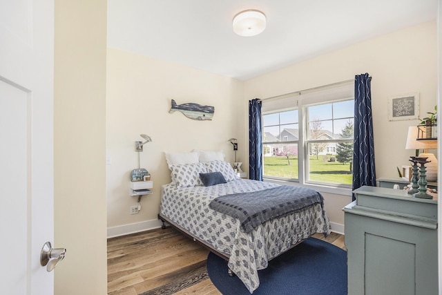 bedroom featuring baseboards and wood finished floors