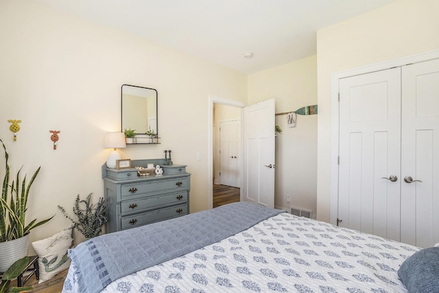 bedroom featuring a closet, visible vents, and wood finished floors