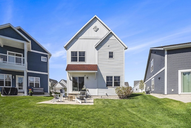 back of house featuring a balcony, a lawn, a patio area, and board and batten siding