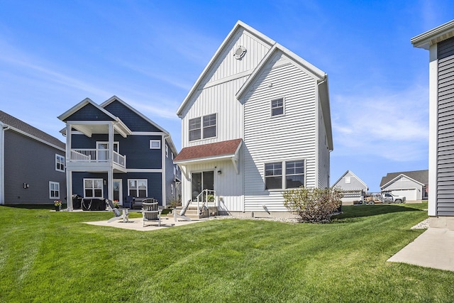 rear view of house with a balcony, a patio area, a yard, and board and batten siding