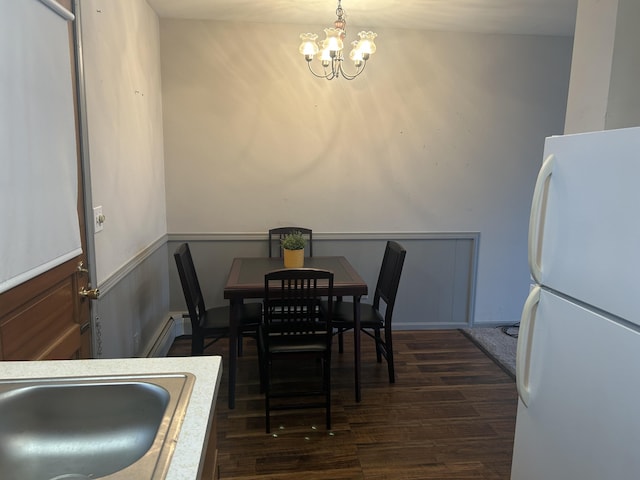 2140 Banner Dr SW, Wyoming, MI 49509 - dining space with a notable chandelier, baseboard heating, and dark wood finished floors