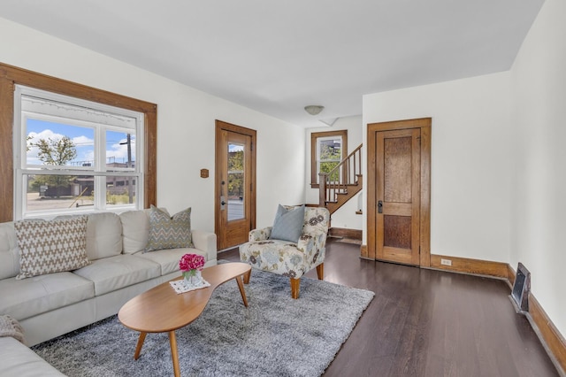 living room with baseboards, dark wood-style flooring, and stairway