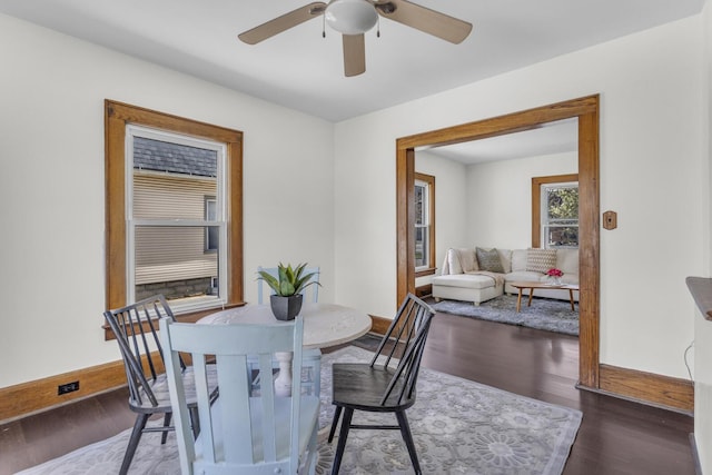 dining space with baseboards, wood finished floors, and a ceiling fan