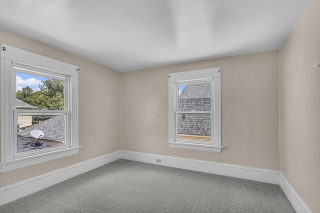 empty room featuring baseboards and carpet flooring