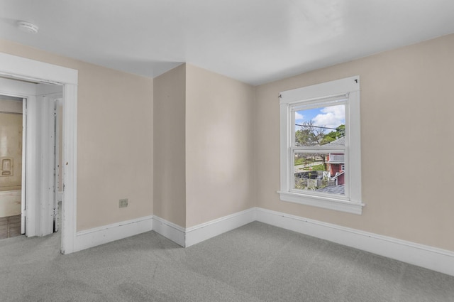unfurnished room featuring carpet and baseboards