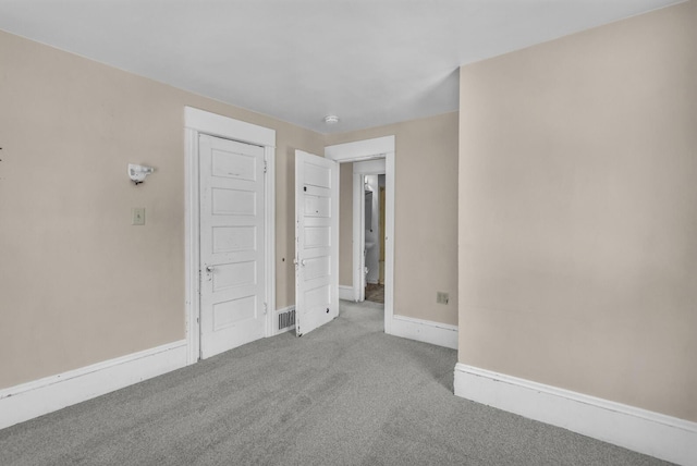 carpeted empty room featuring baseboards
