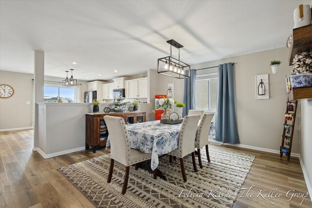 560 Pioneer Trl, Cedar Springs, MI 49319 - dining area featuring light wood finished floors, baseboards, a notable chandelier, and recessed lighting