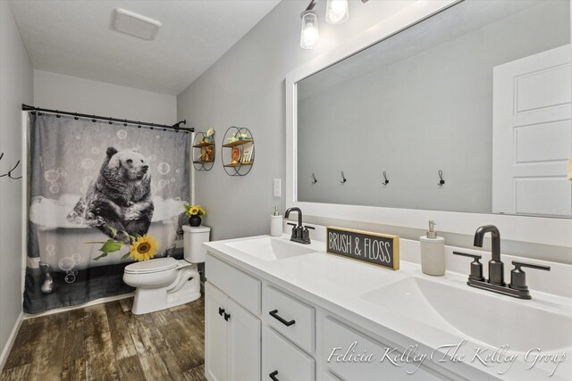 560 Pioneer Trl, Cedar Springs, MI 49319 - full bath with a sink, double vanity, toilet, and wood finished floors