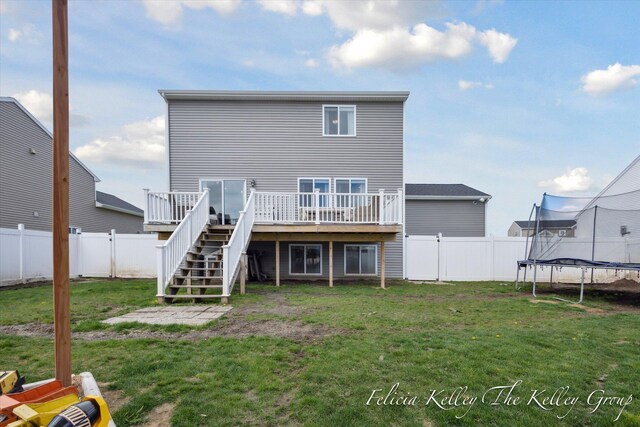 560 Pioneer Trl, Cedar Springs, MI 49319 - rear view of house with a fenced backyard, a deck, a trampoline, and stairs